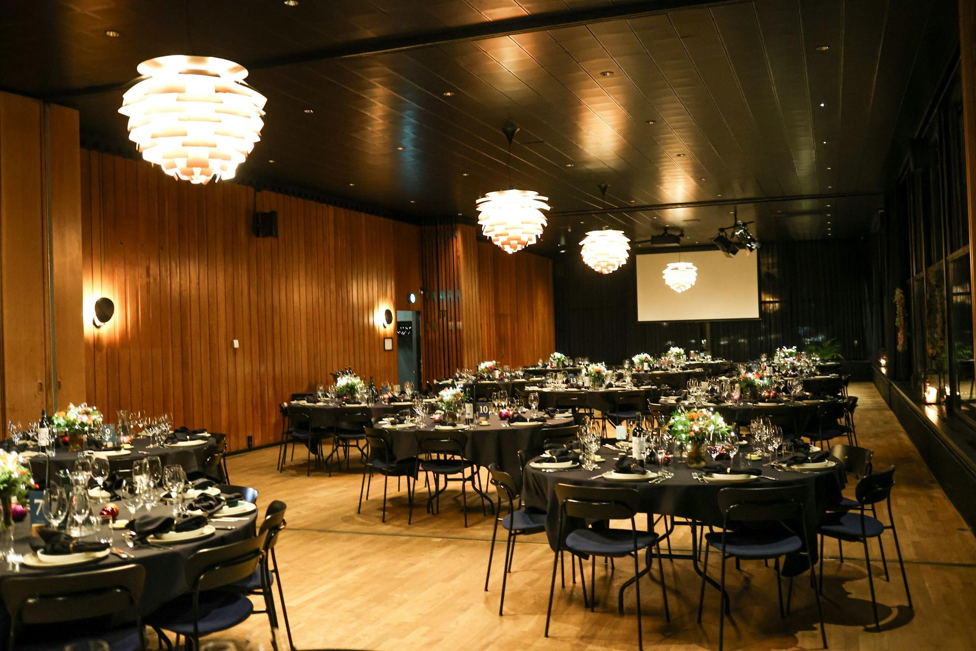 Event space set with round dining tables under warm pendant lights