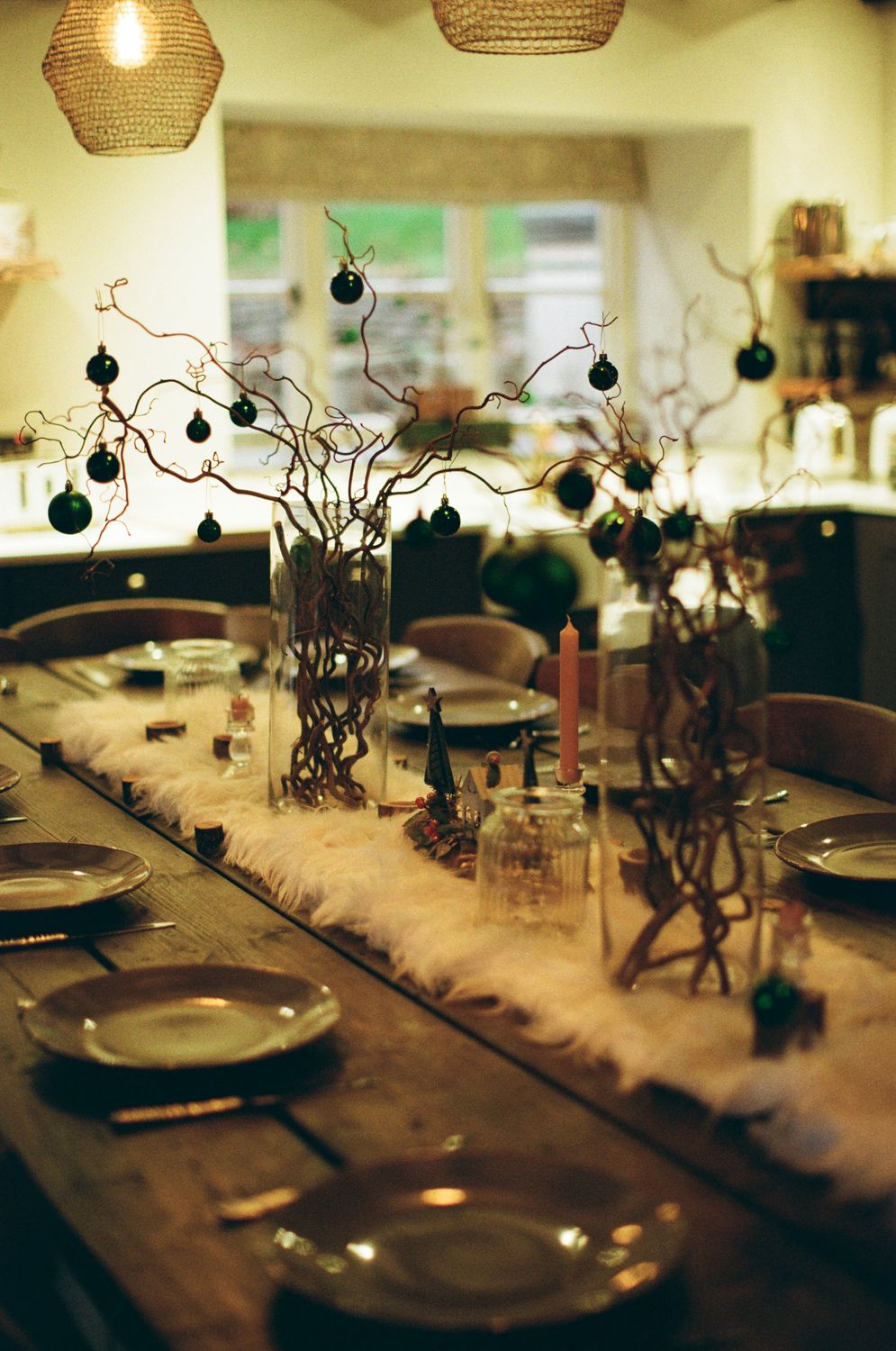 Holiday dinner table decorated with branches and dark ornaments